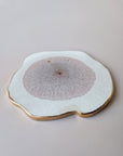 Detail van By Hand Onderzetter Erde, handgemaakt van epoxy in wit en bruin met goudkleurige rand – unieke luxe onderzetter.