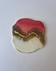 By Hand Onderzetter Tierra, handgemaakt van epoxy in roze, wit en bruin met goudaccent – luxe interieuraccessoire.