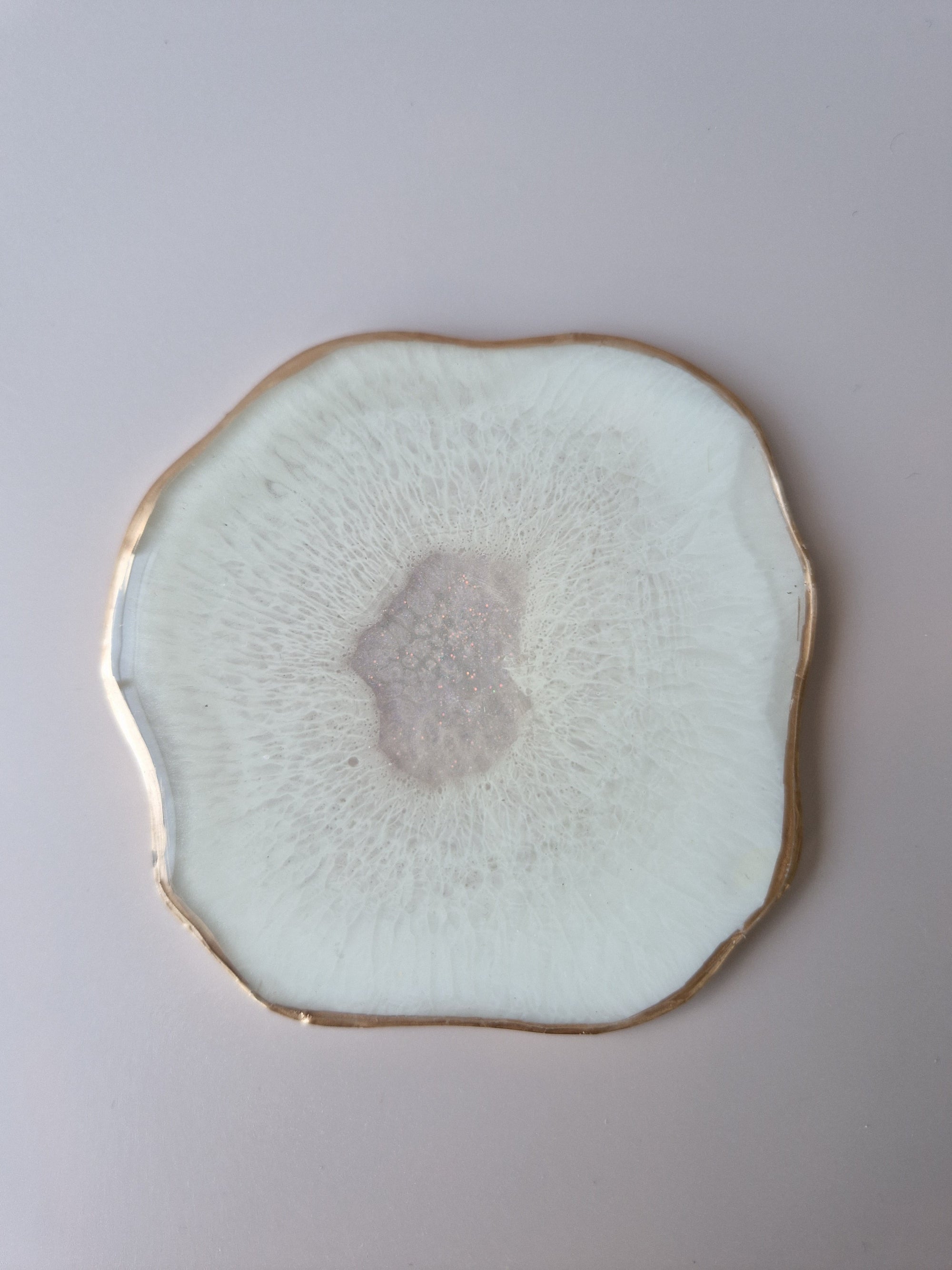 By Hand Onderzetter Ardha, handgemaakt van epoxy in wit met glinsterend centrum en goudkleurige rand – uniek interieuraccessoire
