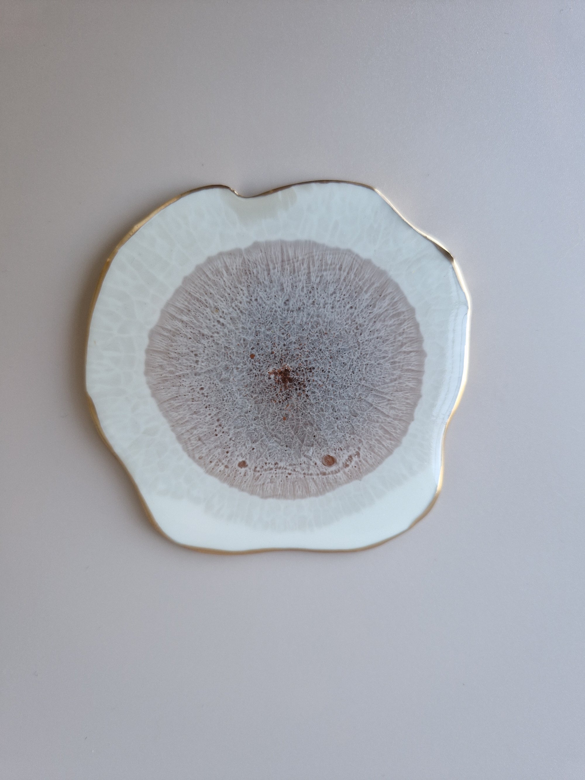 By Hand Onderzetter Erde, bovenaanzicht van handgemaakte epoxy onderzetter in wit en bruin met goudaccent – unieke interieuraccessoire.