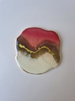 By Hand Onderzetter Tierra, handgemaakt van epoxy in roze, wit en bruin met goudaccent – luxe interieuraccessoire.