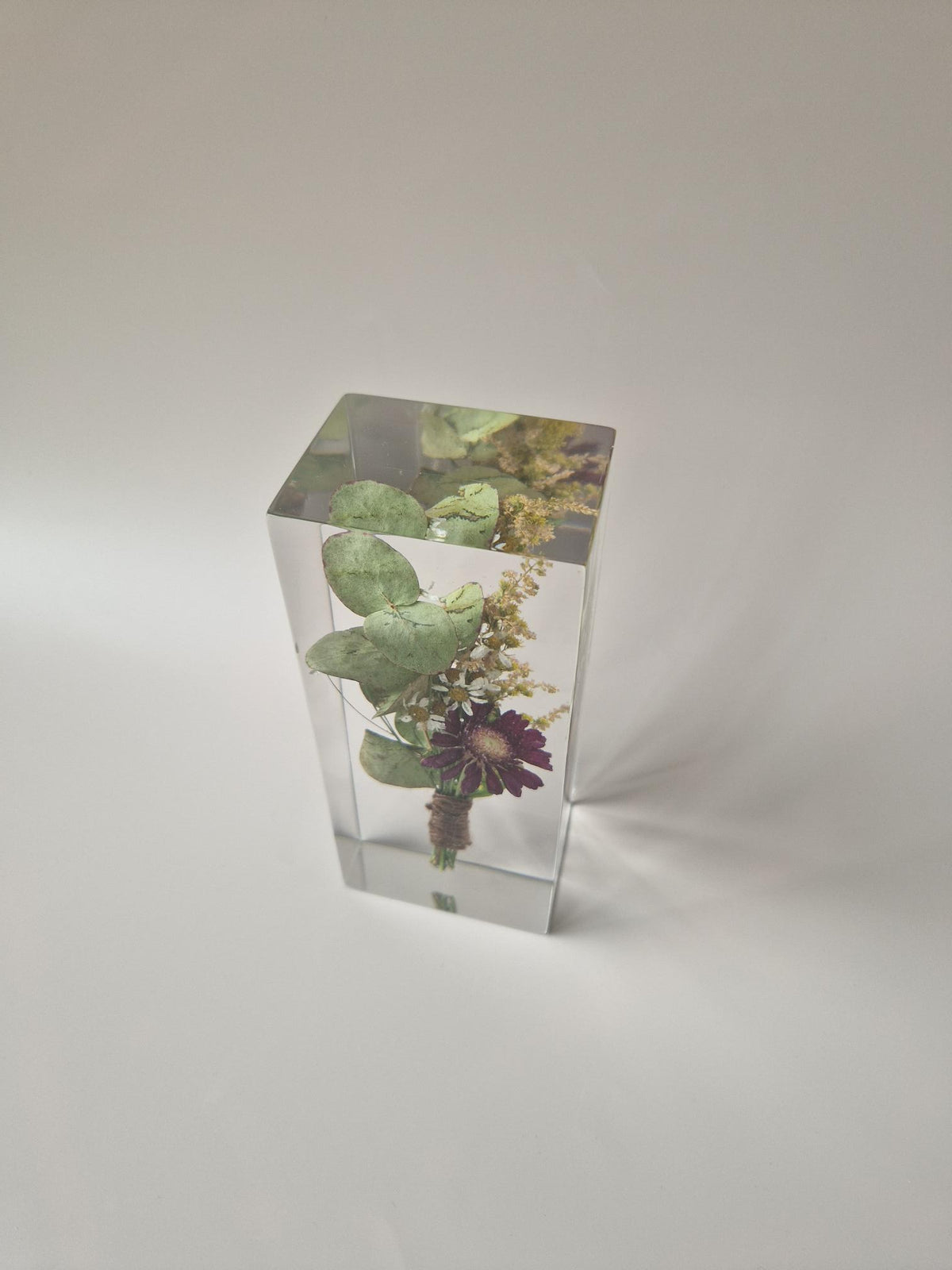 Corsage van de bruidegom verwerkt in transparante epoxy, bekeken van schuin bovenaf