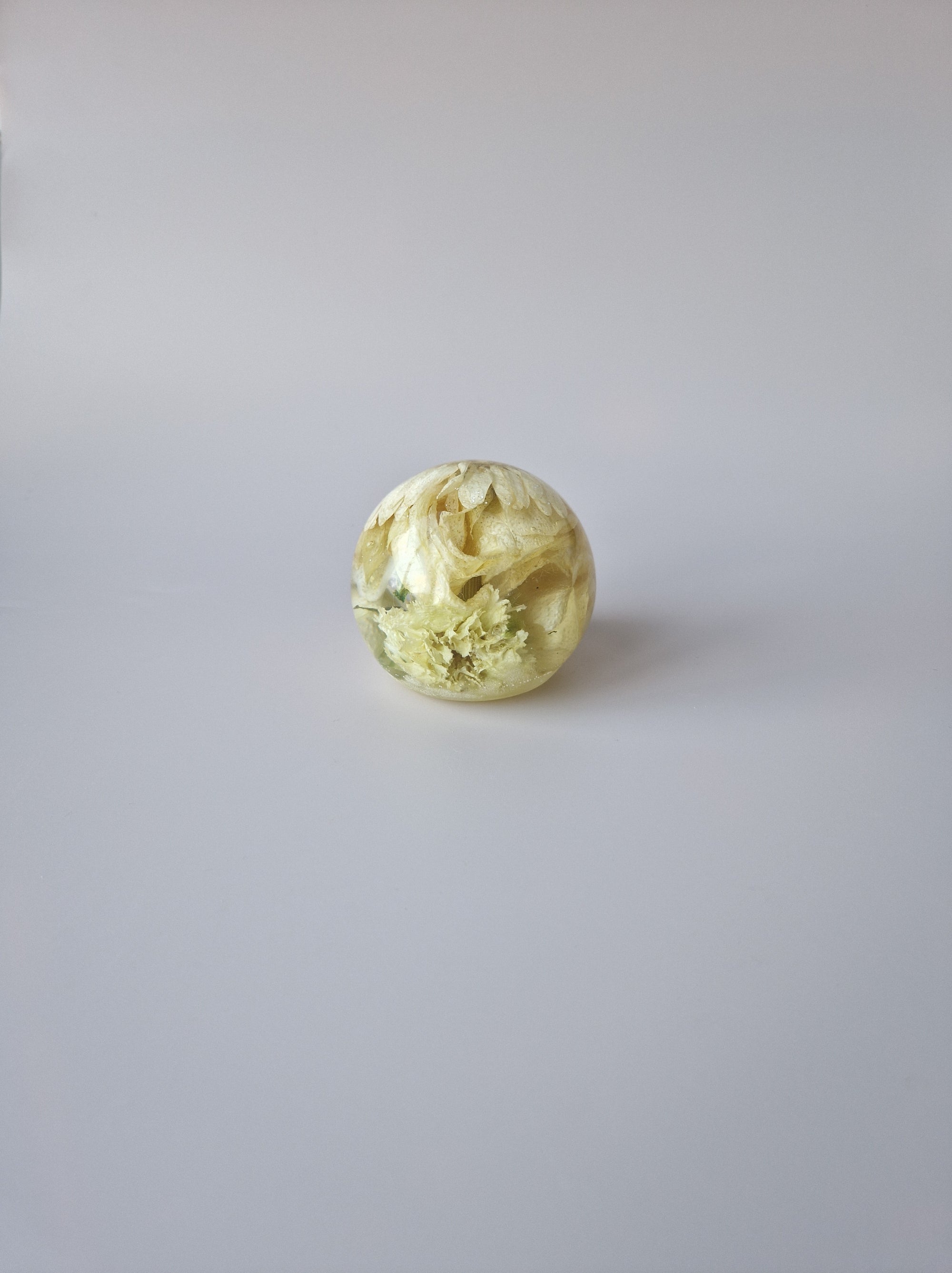 Flower Shower Bol Uitvaart met witte bloem, handgemaakt van epoxy om rouwbloemen en herinneringen tastbaar te bewaren.