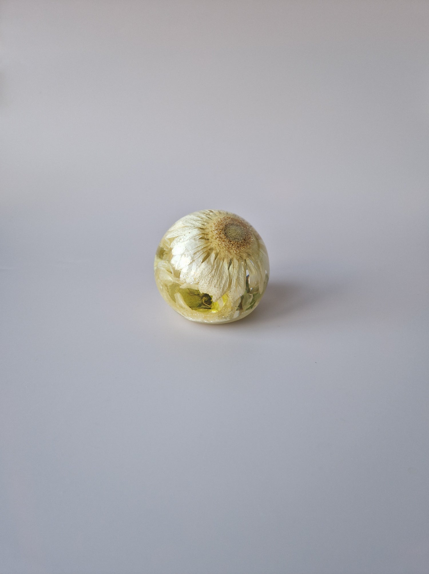 Flower Shower Bol Uitvaart met witte bloem, handgemaakt van epoxy om rouwbloemen en herinneringen tastbaar te bewaren.