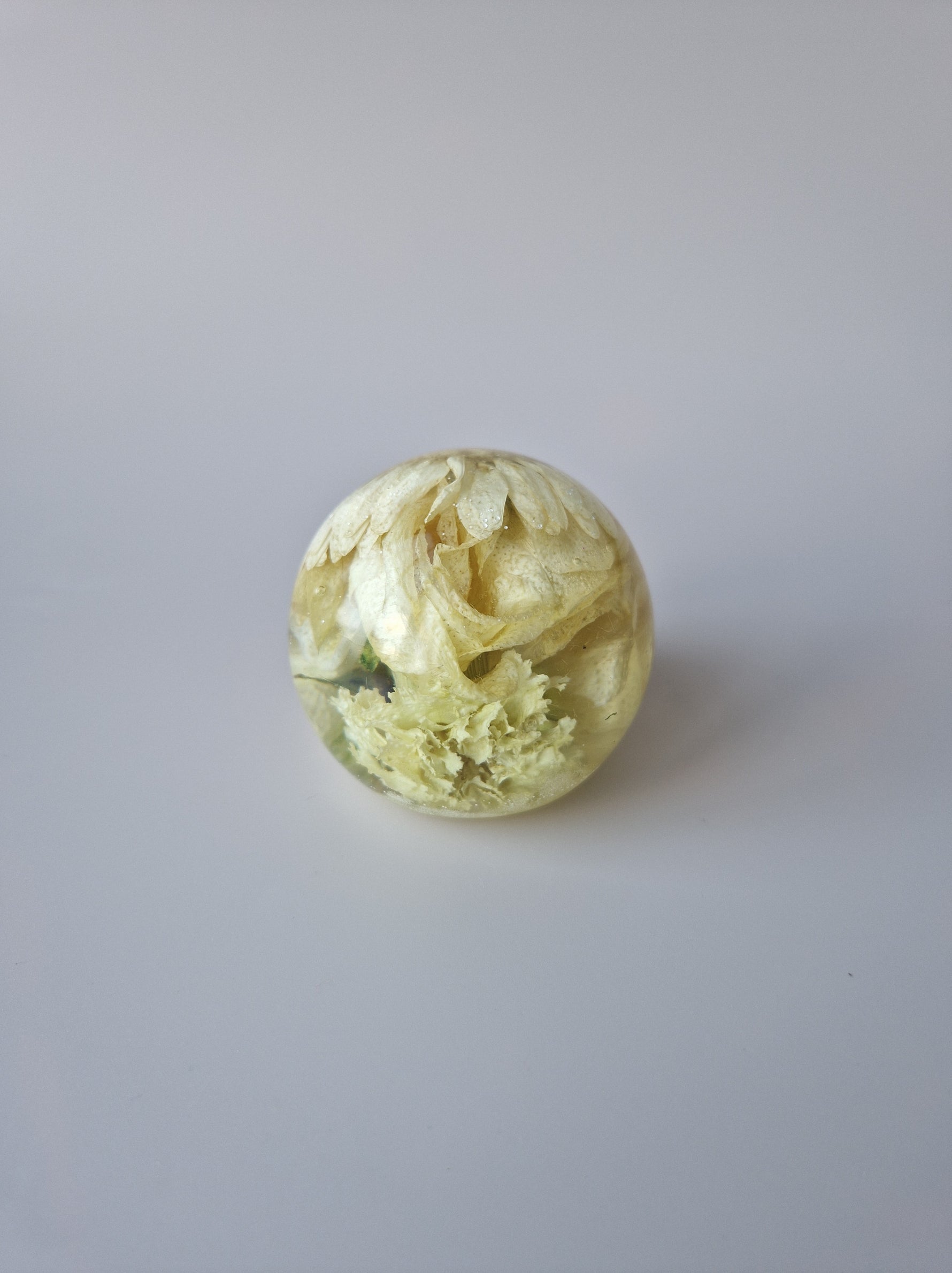 Flower Shower Bol Uitvaart met witte bloemen, handgemaakt van epoxy om rouwbloemen en herinneringen te bewaren.