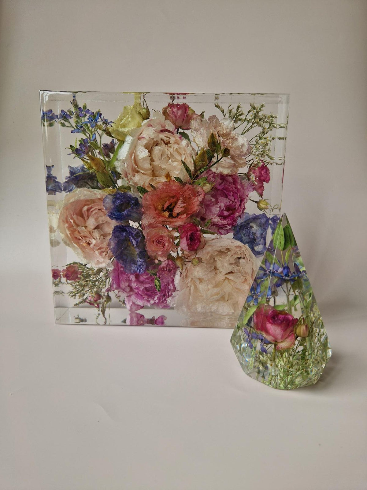 Flower Shower ringhouder 7 x 12 cm naast een groter epoxy aandenken met bloemen uit het bruidsboeket