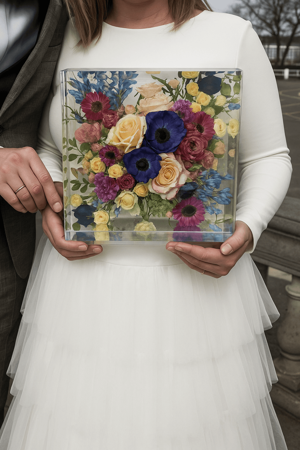 Bruid houdt haar bruidsboeket vast dat is vereeuwigd in een transparante Flower Shower van Moonstork, een handgemaakt kunstwerk van epoxy vol kleur en betekenis.