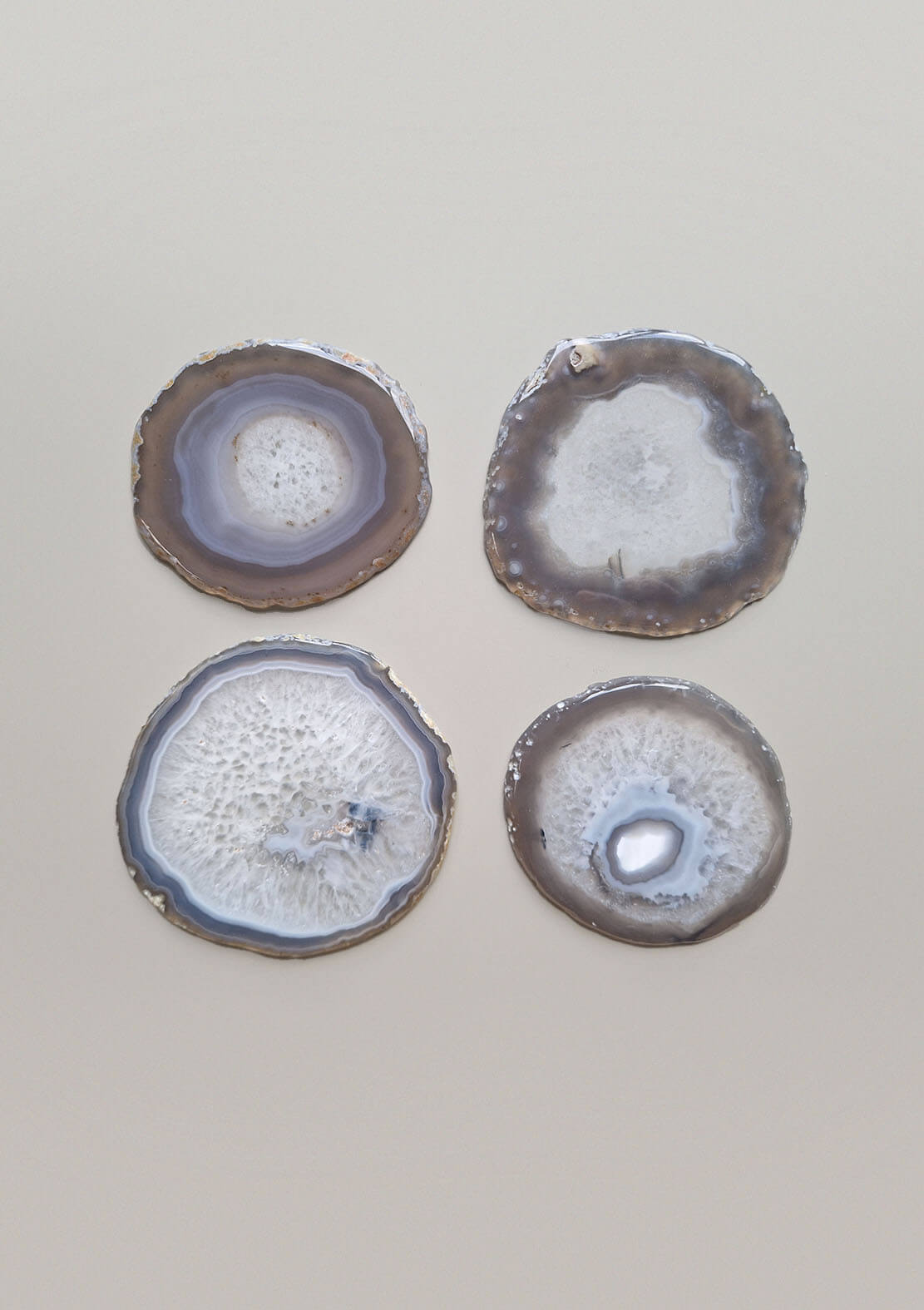 Set van vier By Nature Onderzetters Lua – Agaat in taupe, grijsblauw en wit, elk met unieke patronen.