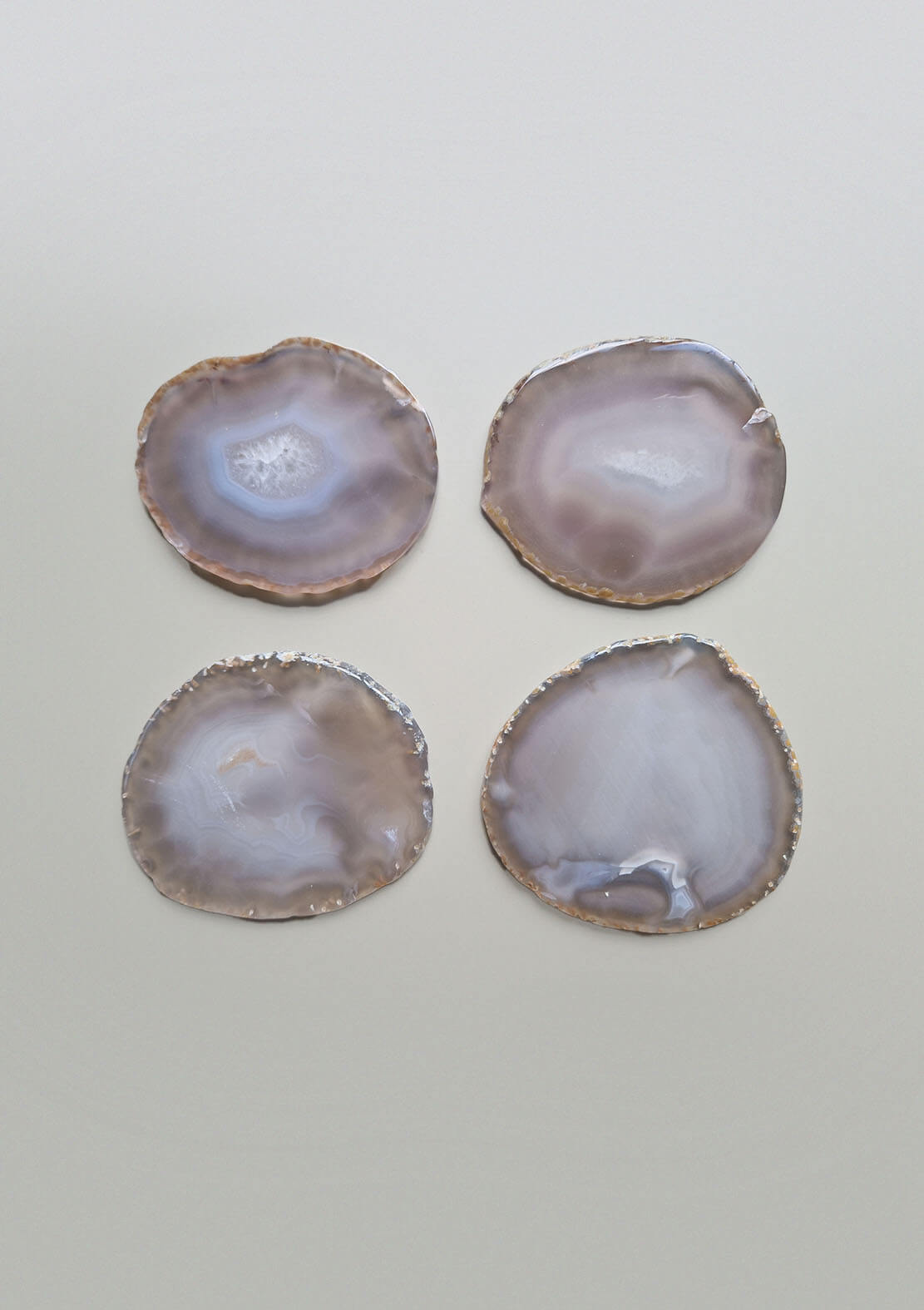 Set van vier By Nature Onderzetters Maan, agaat in zachte grijs-beige tinten, elk met een uniek patroon.